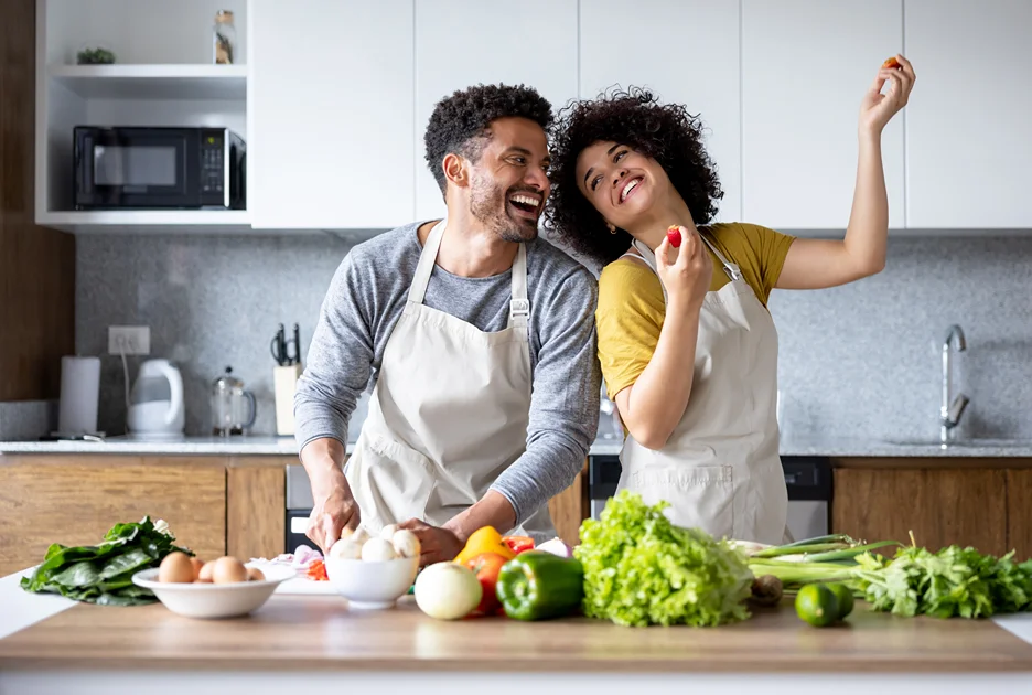 a couple cooking their meal happily in the kitchen